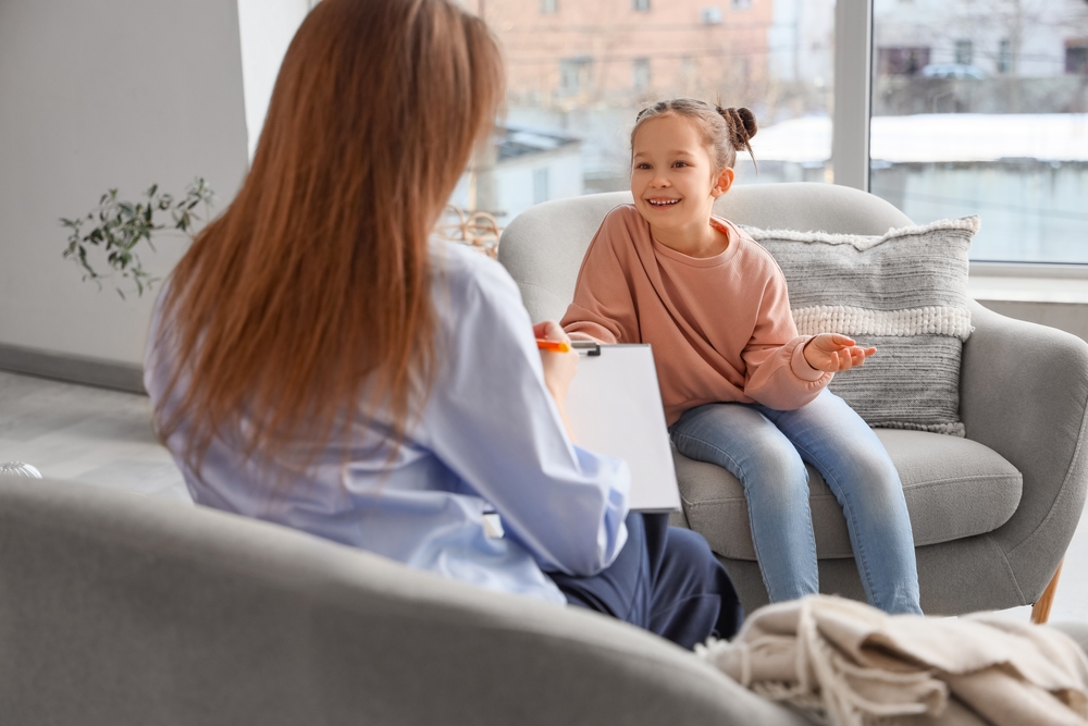 A child counsellor sitting with a child during a counselling session
